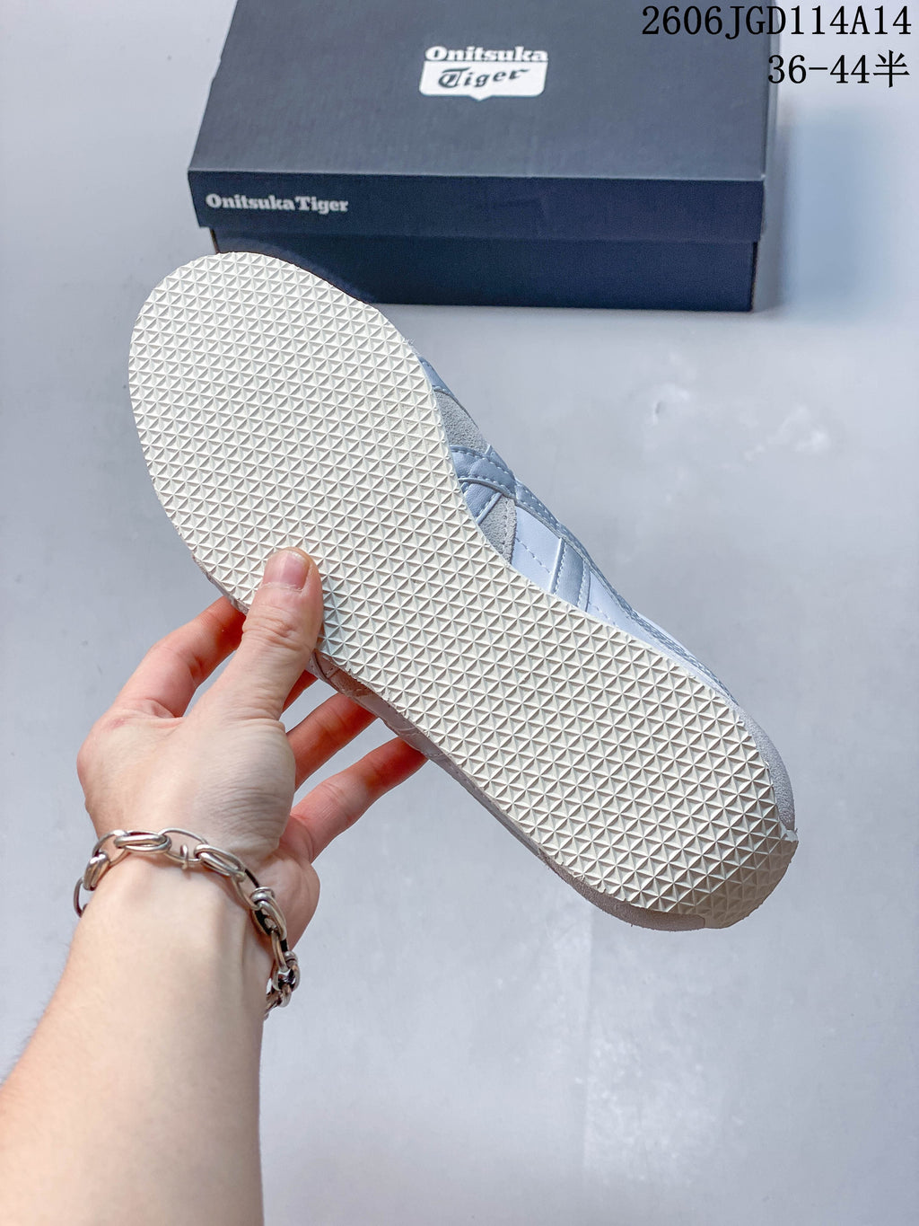 Close-up of the textured outsole on a white and silver Runspark sneaker