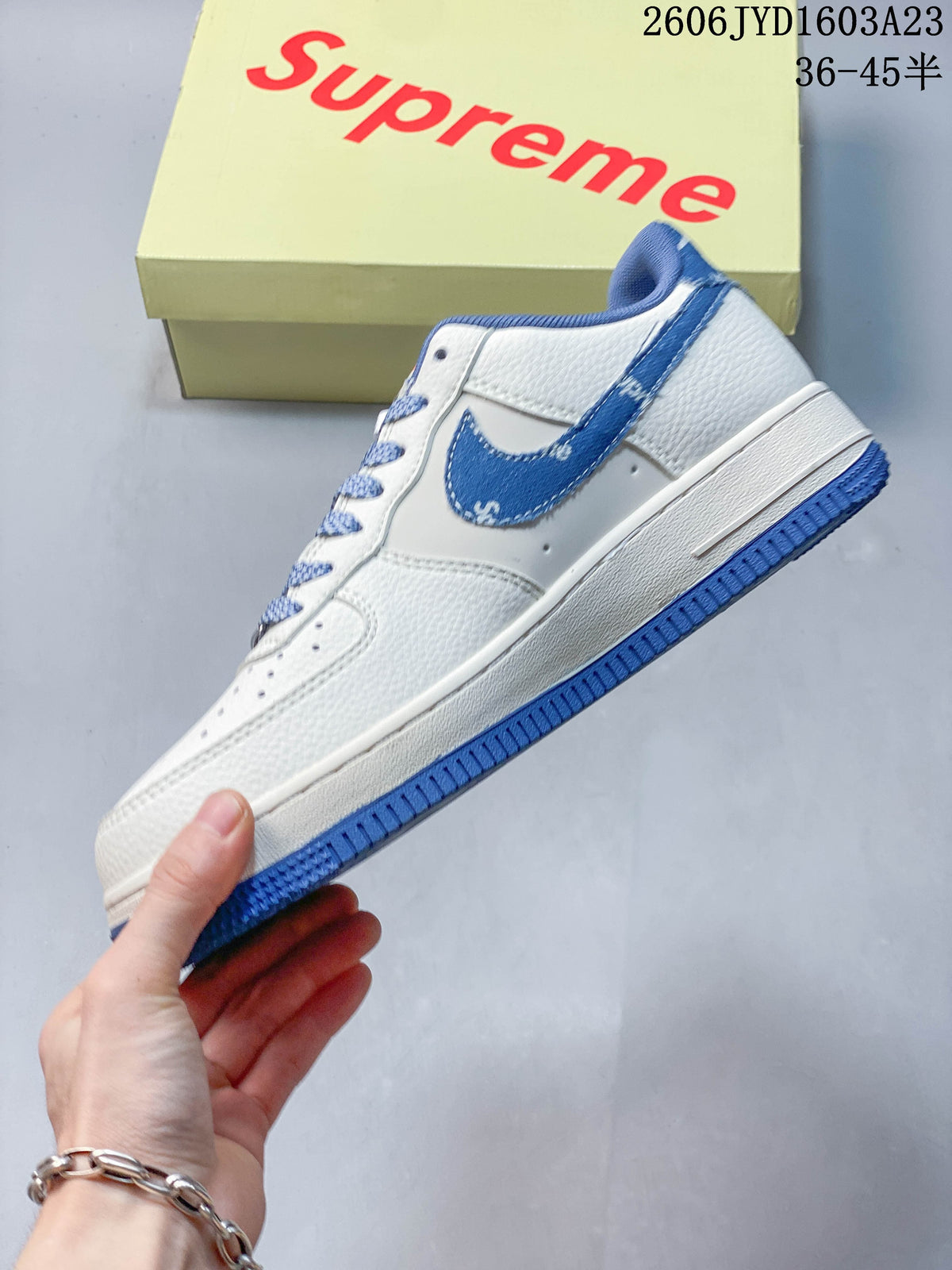 Side profile of a white low-top sneaker with blue accents and a blue outsole