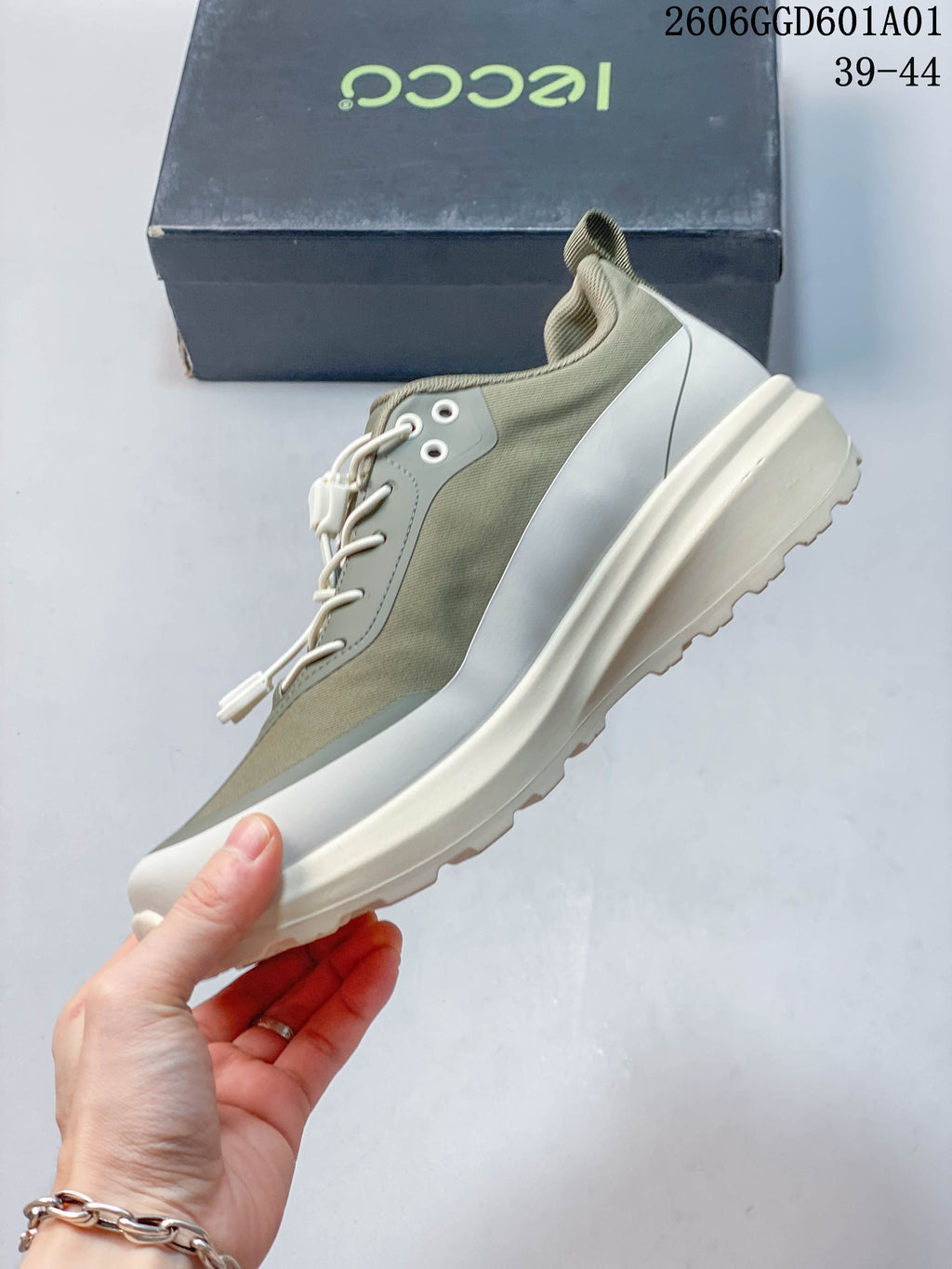 Side profile of a sage and cream low-top sneaker with cord-style laces and a chunky sole; image overlay lists sizes 39–44.