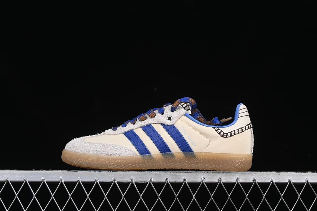 Side view of an off-white adidas Wales Bonner Samba sneaker with blue stripes, multicolored laces and gum-colored sole.