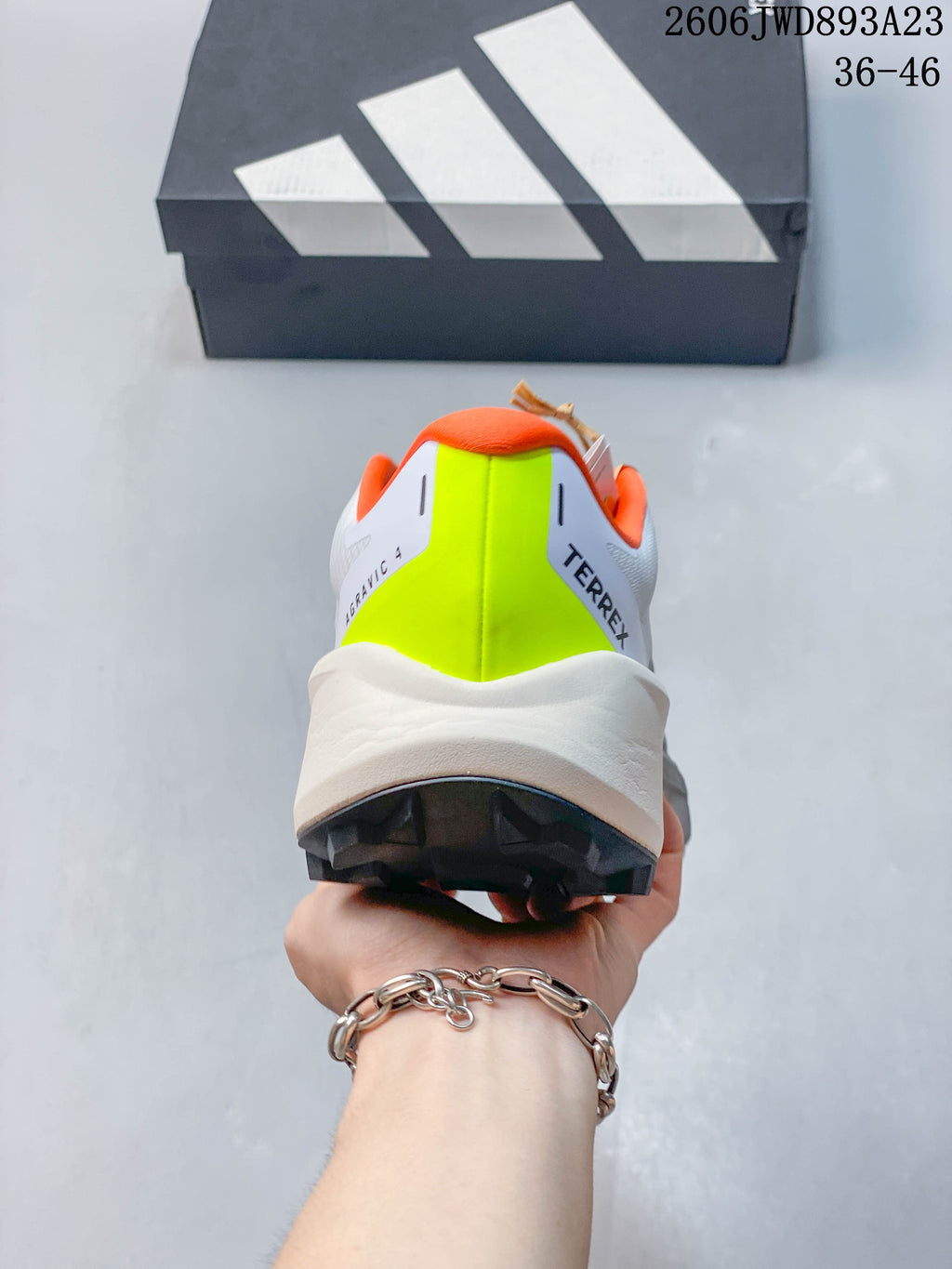 Rear view showing the bright lime heel panel and orange collar.