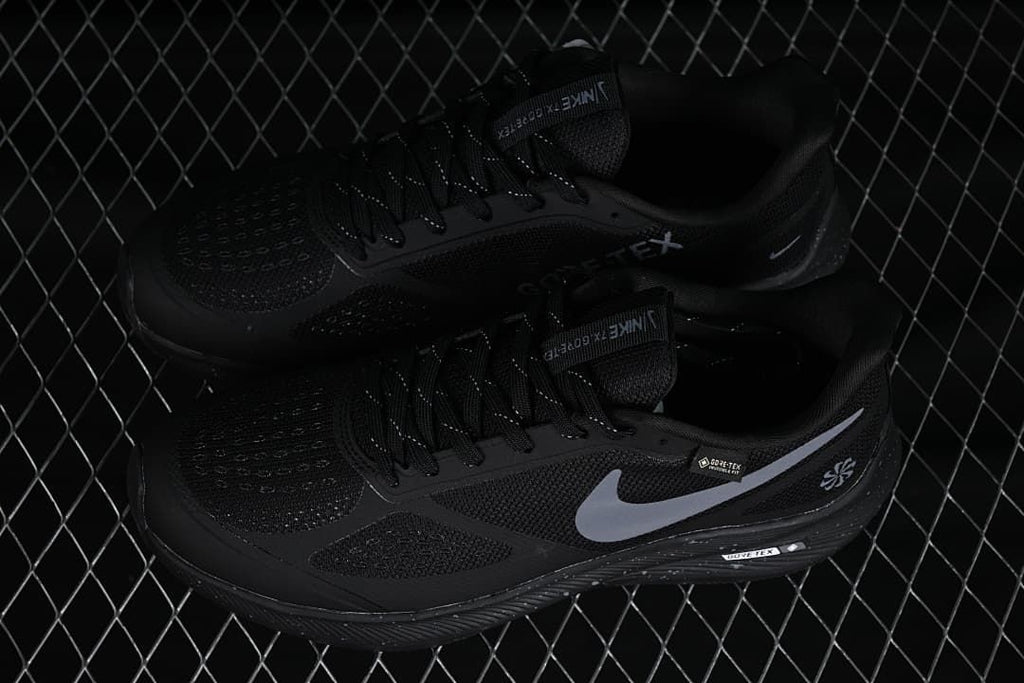 Pair of black Nike running shoes with gray Swooshes, shown from above and the side.