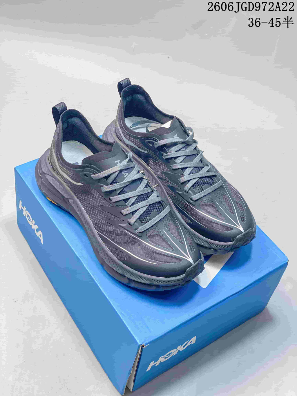 Pair of charcoal-gray HOKA Mafate Speed 4 Lite shoes on a blue shoe box