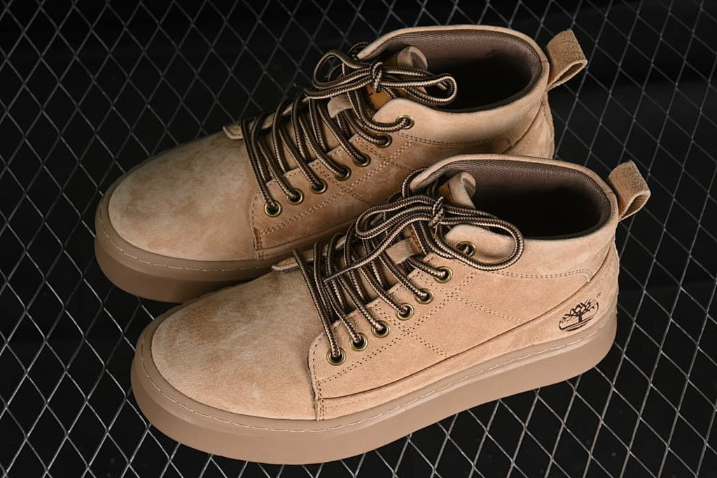 Pair of sand-colored mid-top boots shown from above and the side