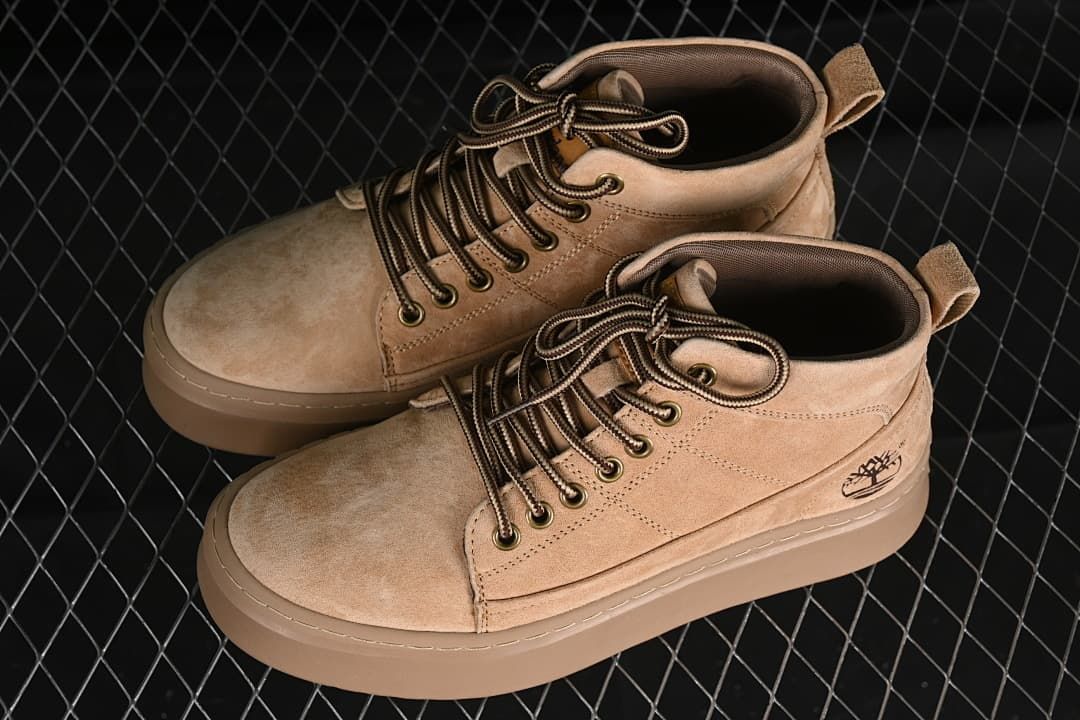 Pair of sand-colored mid-top boots shown from above and the side