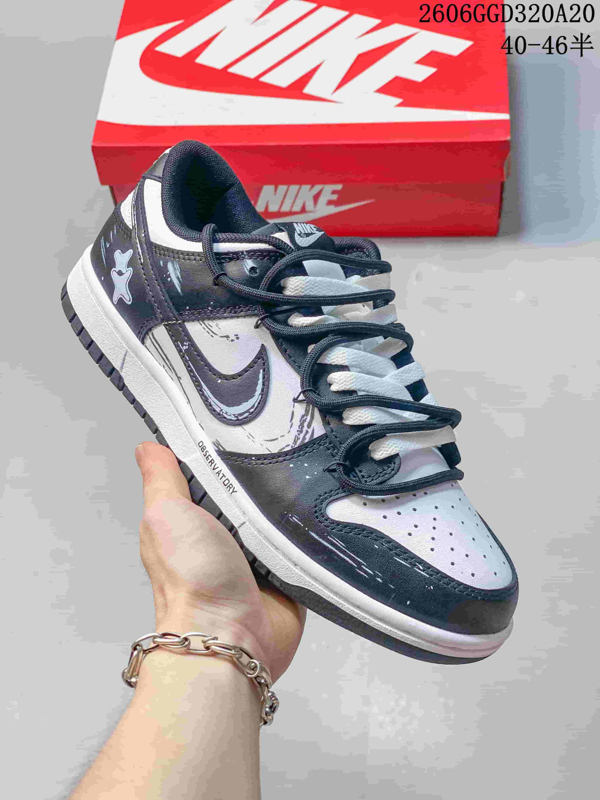 Angled side view of a black, white, and gray low-top sneaker with graphic accents