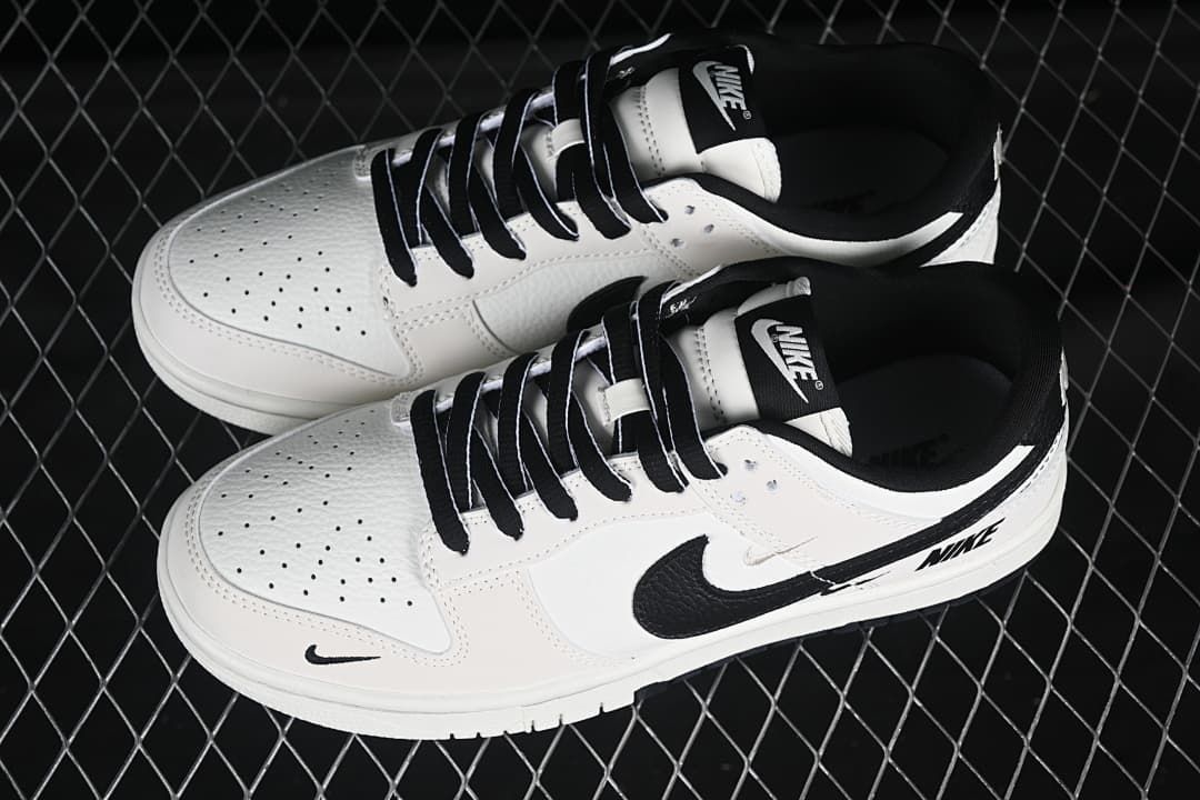 Top view of a pair of white and black low-top sneakers with black laces and perforated toe panels.
