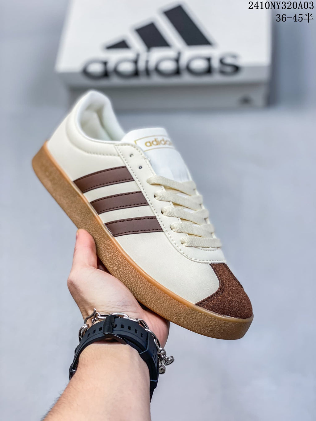 Angled side view of the cream sneaker with brown accents and gum-colored sole