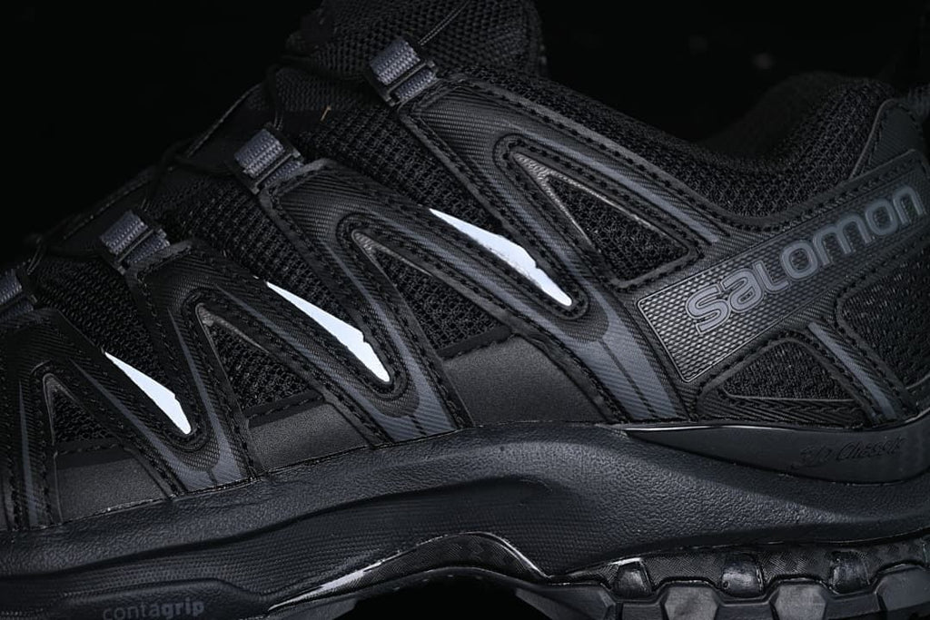 Close-up of the black upper, side overlays, and Salomon branding