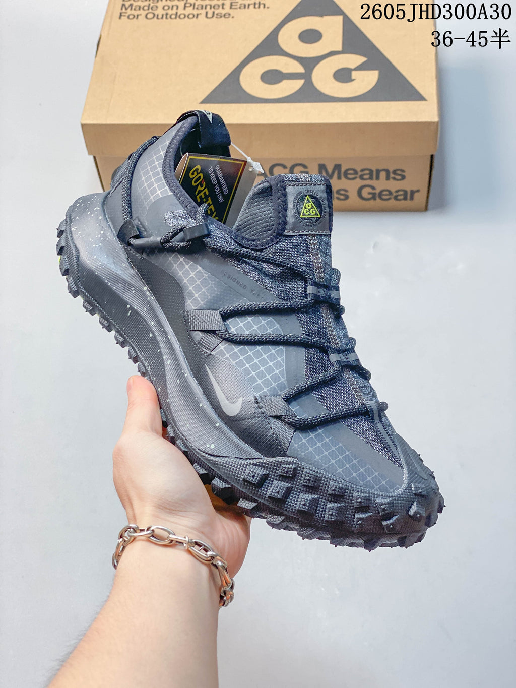 Side profile of the gray shoe with grid-patterned panels and lugged sole