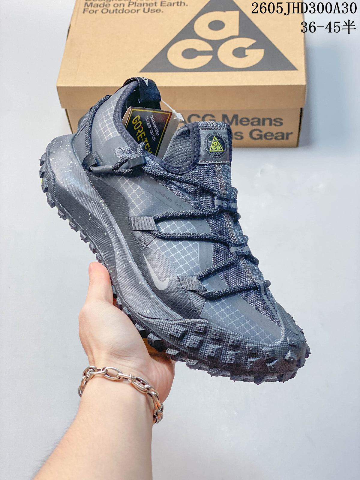 Side profile of the gray shoe with grid-patterned panels and lugged sole