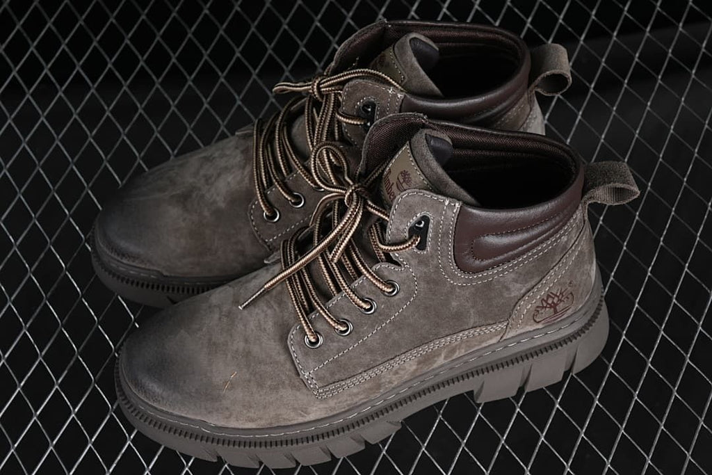 Pair of brown mid-top lace-up boots shown at an angle