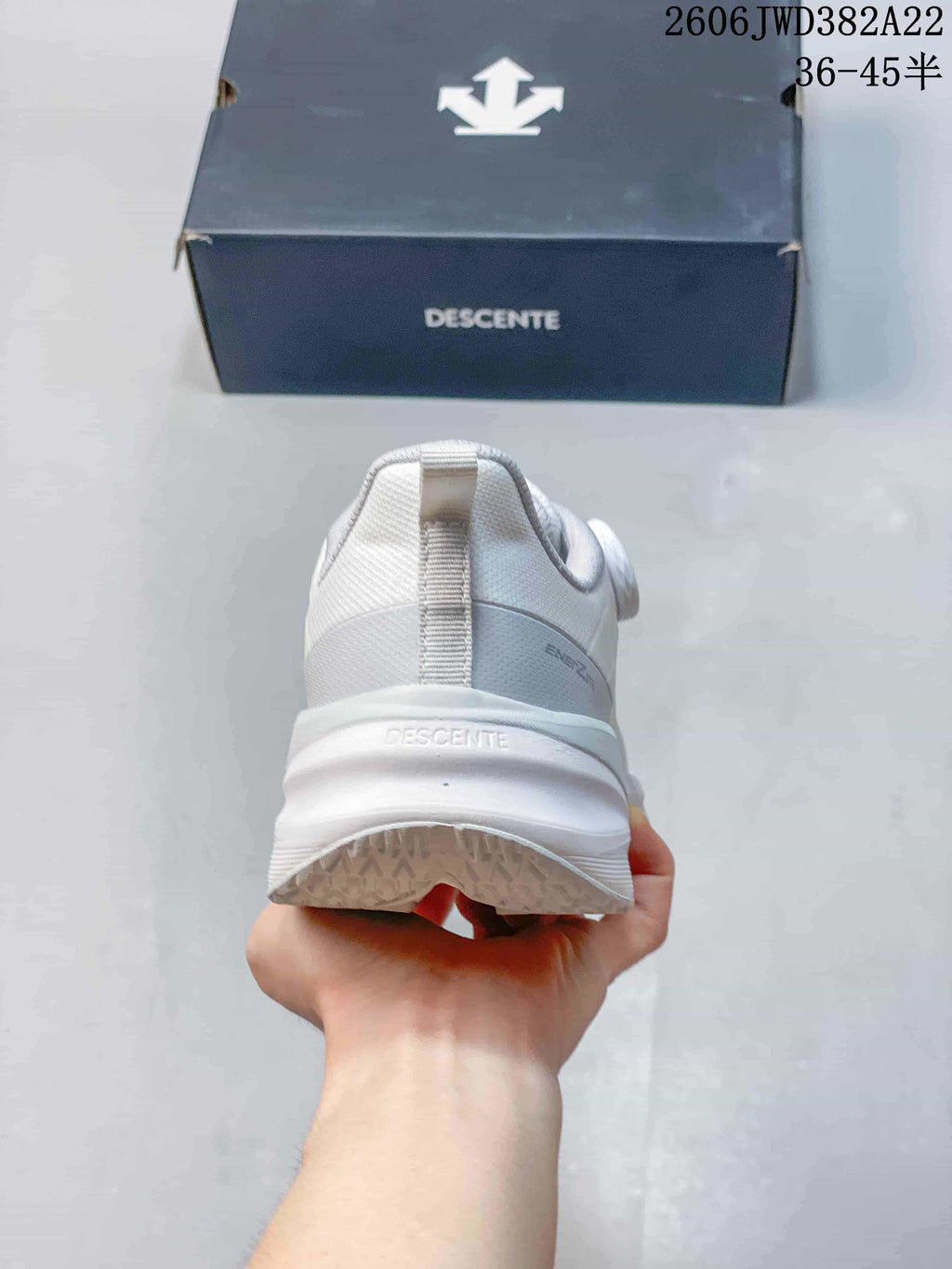 Rear view of the white DESCENTE running shoe and thick midsole.