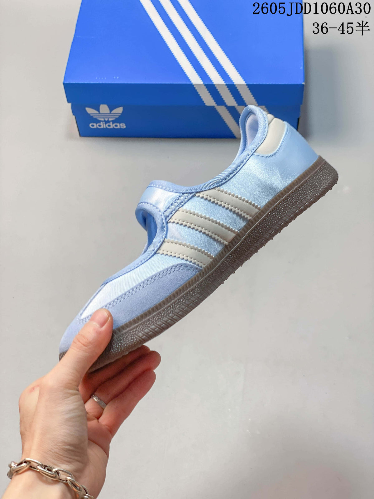 Side profile of a pale blue sneaker with light stripes and a brown outsole