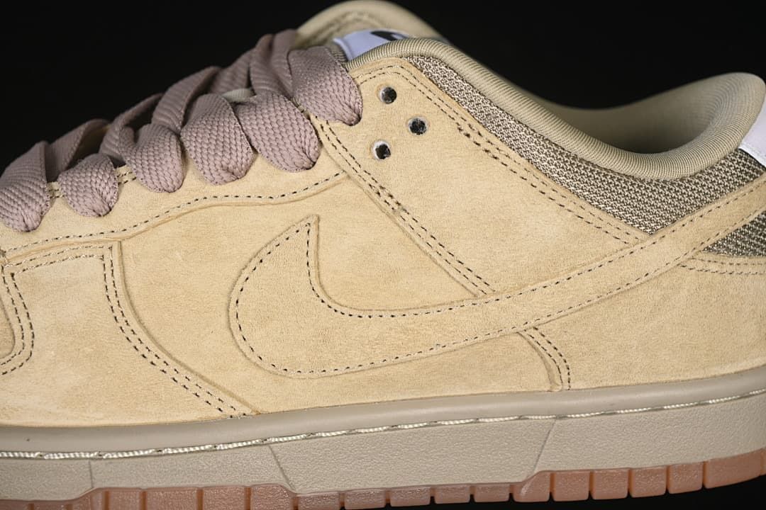 Close-up of the tan side panel, Swoosh, and mauve-toned laces