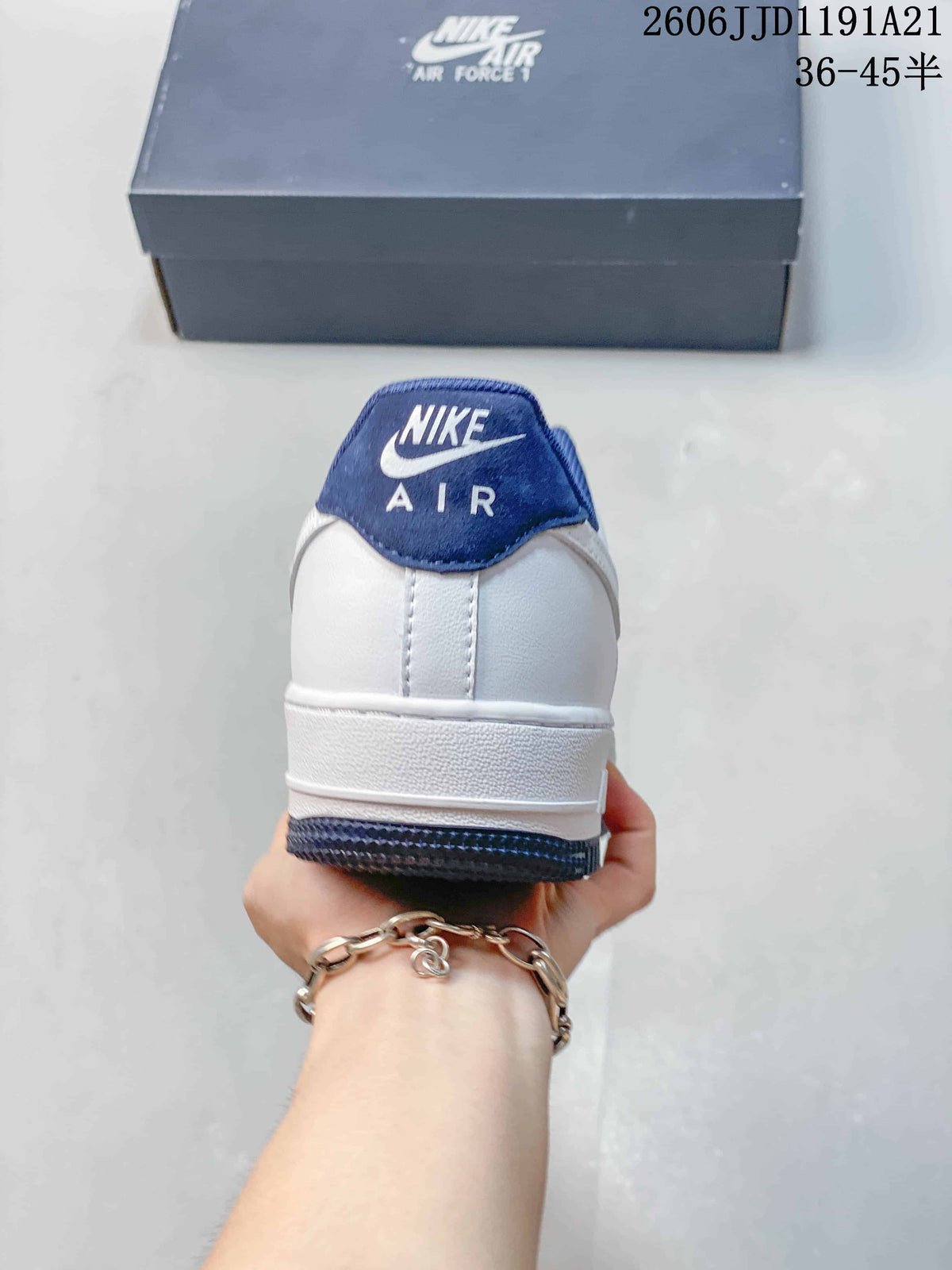 Rear view of a white Nike Air Force 1 Low sneaker with a blue heel tab.