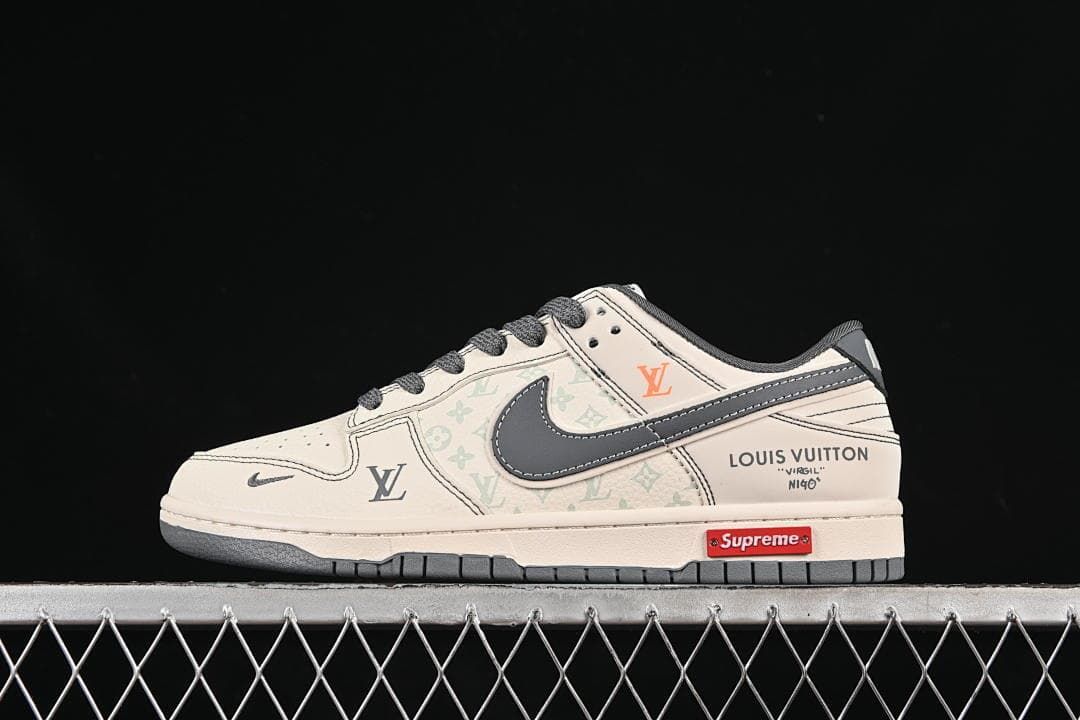 Side view of a cream and grey low-top sneaker with dark laces, printed panels, and a contrasting Swoosh