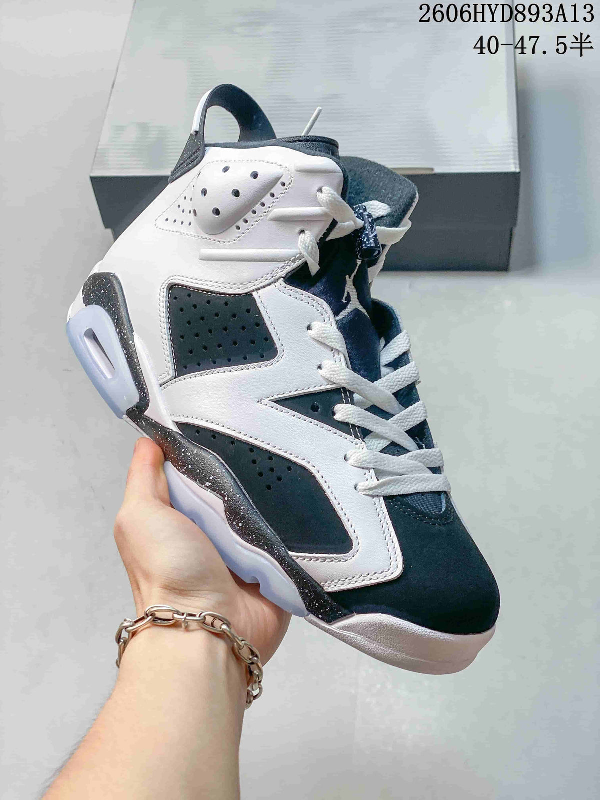 Angled side view of the white and dark high-top sneaker with perforated panels