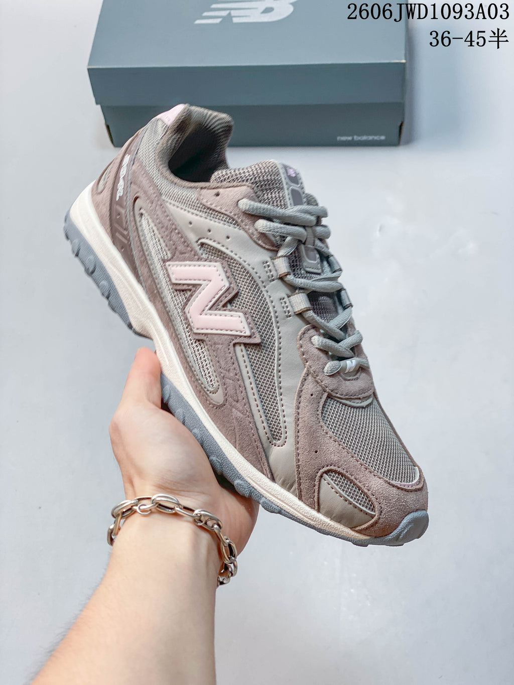 Angled side view of the gray-brown sneaker with pale pink accents