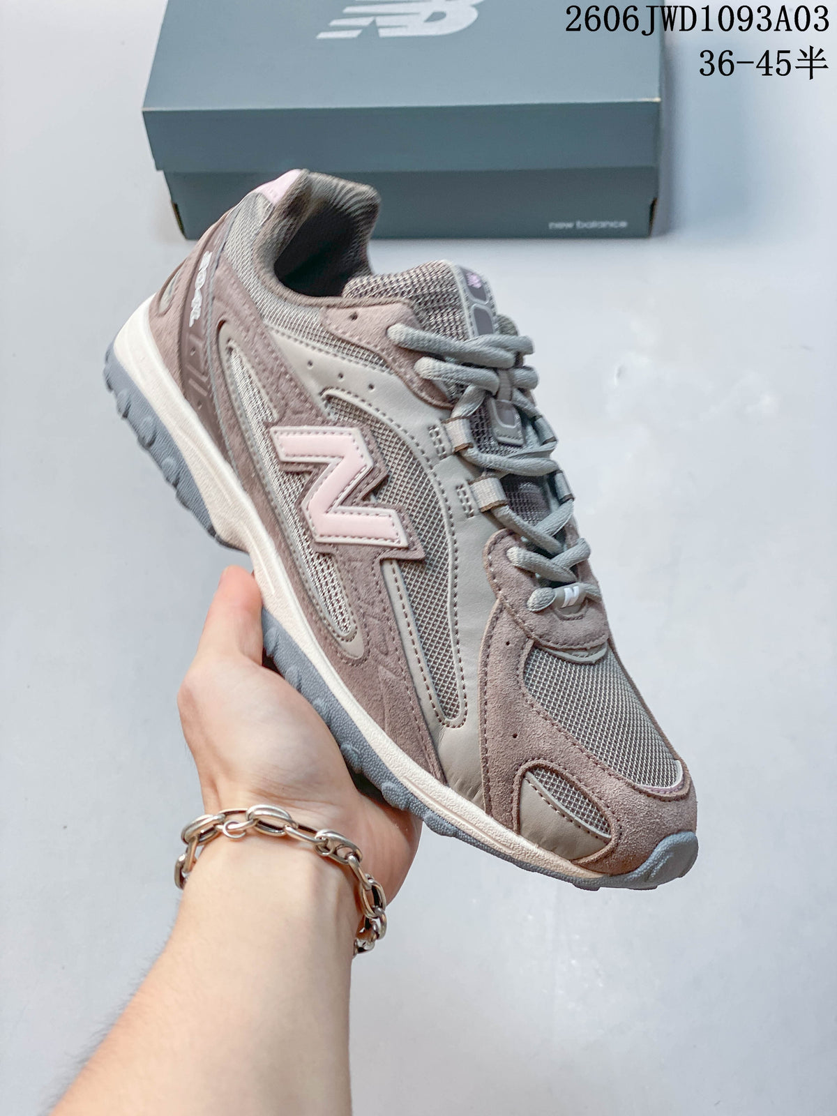 Angled side view of the gray-brown sneaker with pale pink accents