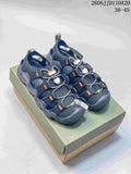 Pair of dark gray and navy KEEN Newport H2 sandals with orange accents, shown from above on a shoebox.