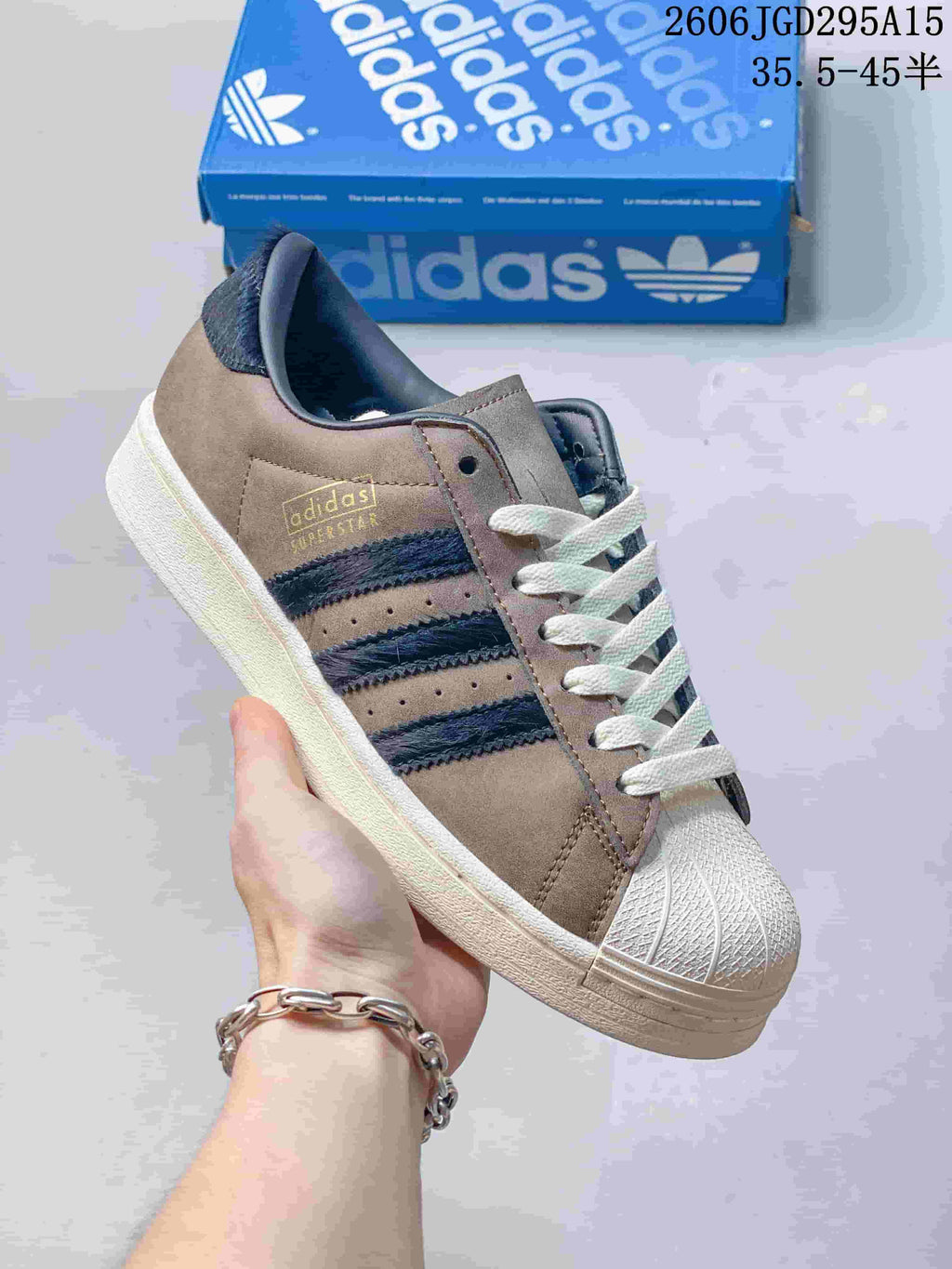 Taupe and navy sneaker with a shell toe and three side stripes