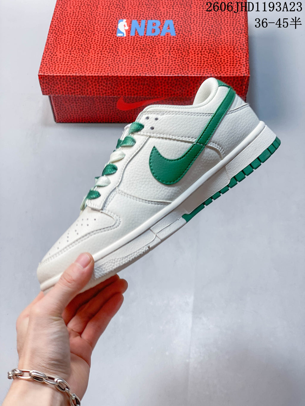 Side view of a white and green low-top sneaker showing green Swoosh accents