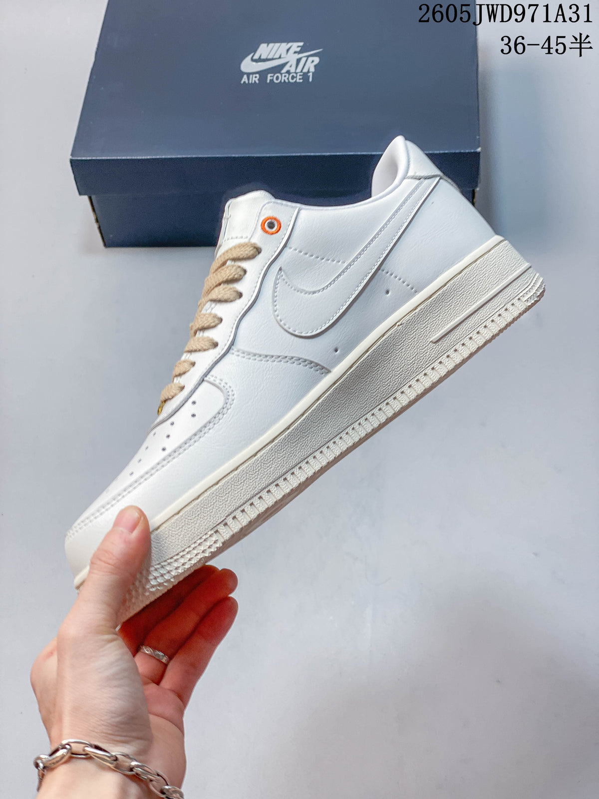 Side profile of a white low-top sneaker with a beige layered side detail and beige-toned sole.