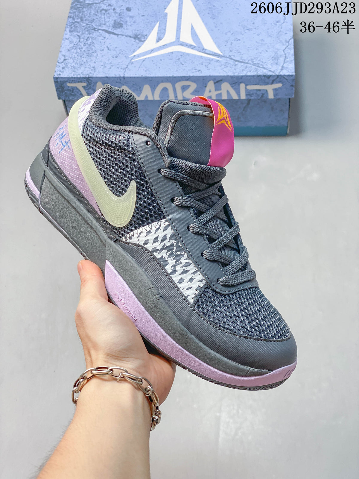 Dark gray Nike Ja 1 EP shoe with pale logo, pink accents and patterned panels.