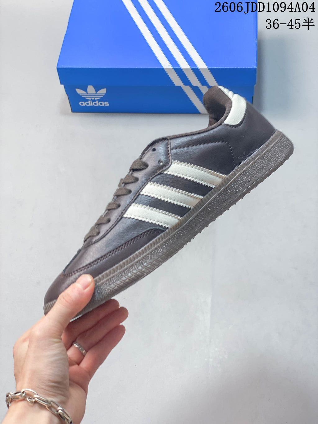 Side profile of a dark brown low-top sneaker with light-colored stripes and a gum-tone outsole