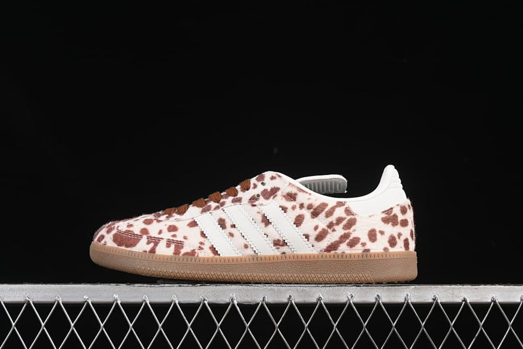 Side view of cream and brown spotted adidas Samba-style sneaker with white stripes and gum sole