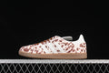 Side view of cream and brown spotted adidas Samba-style sneaker with white stripes and gum sole