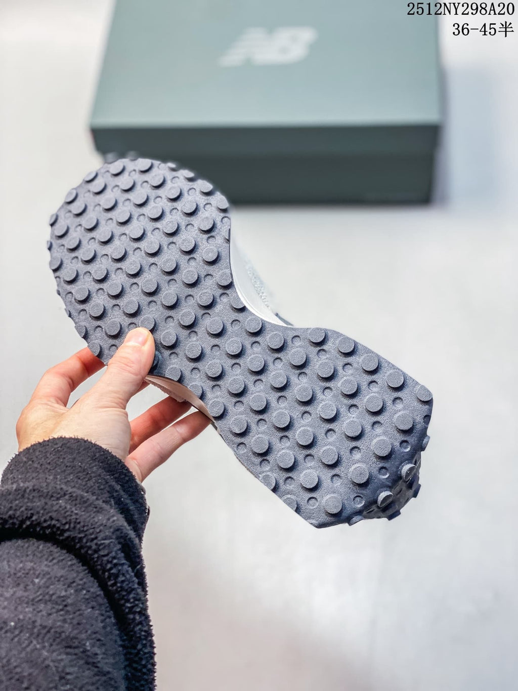 Close-up of the studded outsole on a gray and navy sneaker