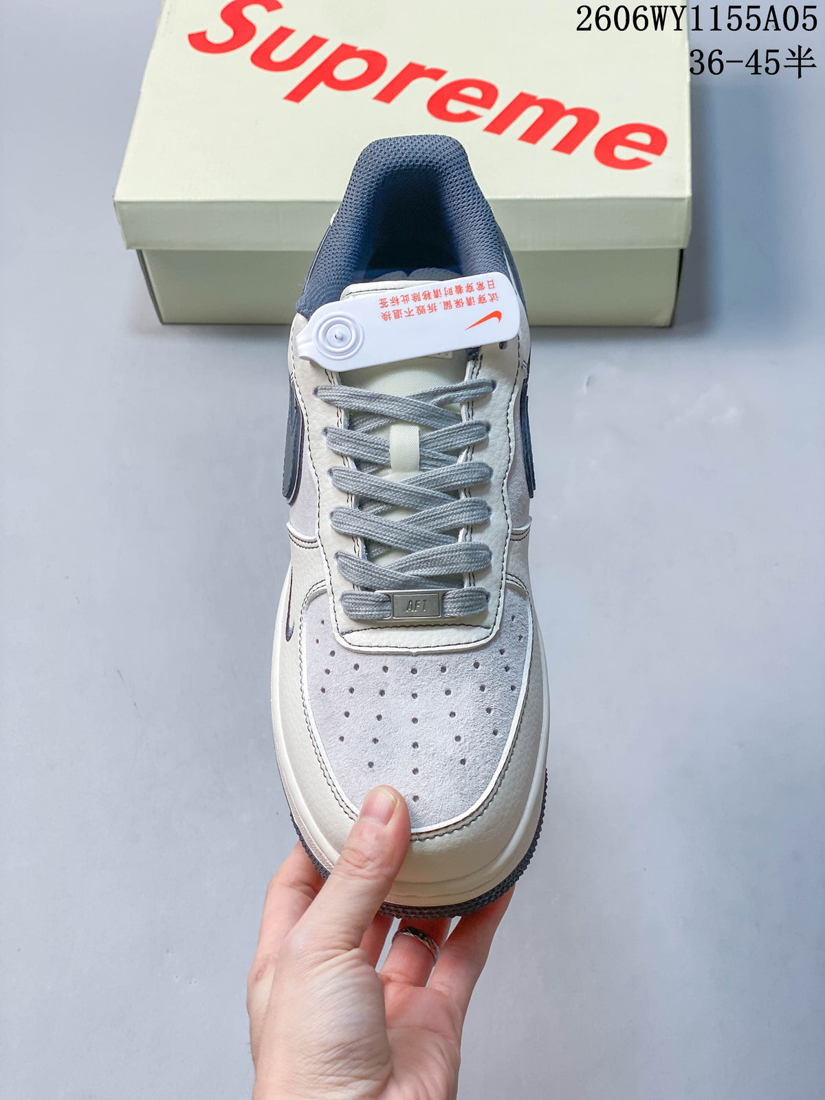 Top view of a lace-up low-top sneaker with a perforated toe and slate-blue details