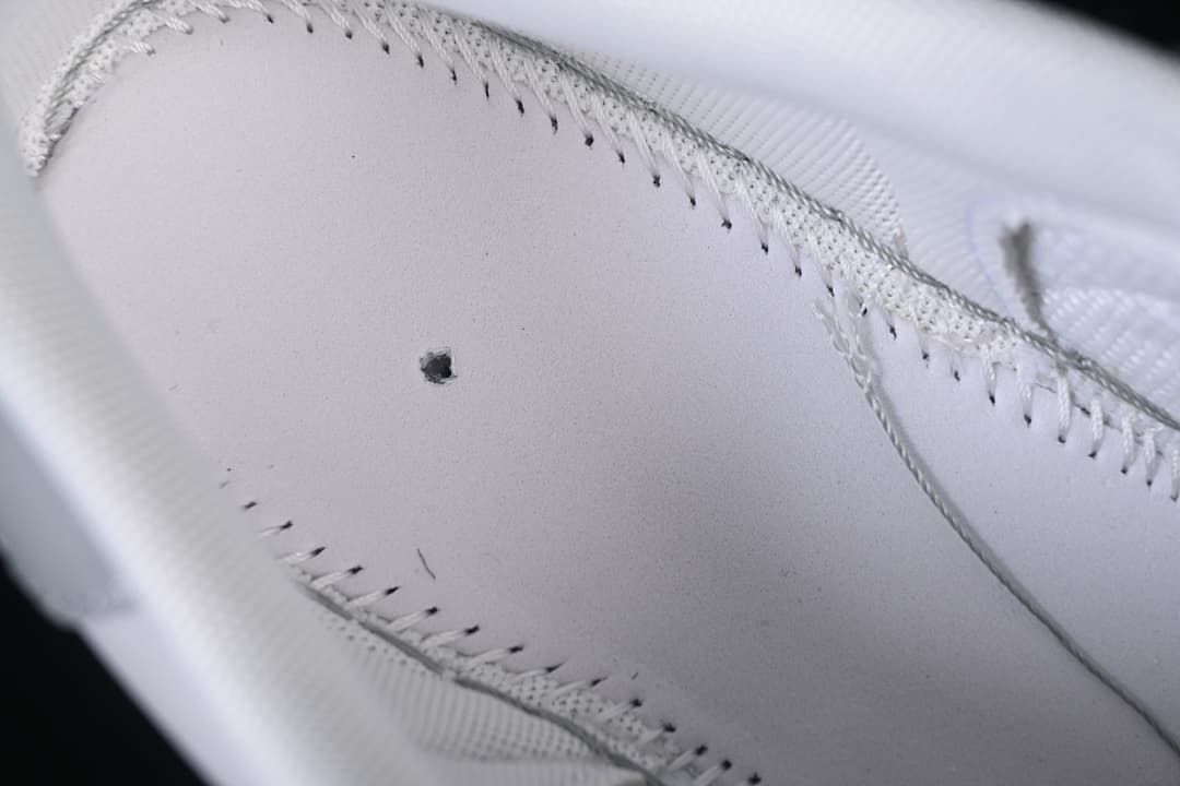 Close-up of the sneaker's stitched upper and ventilation hole.