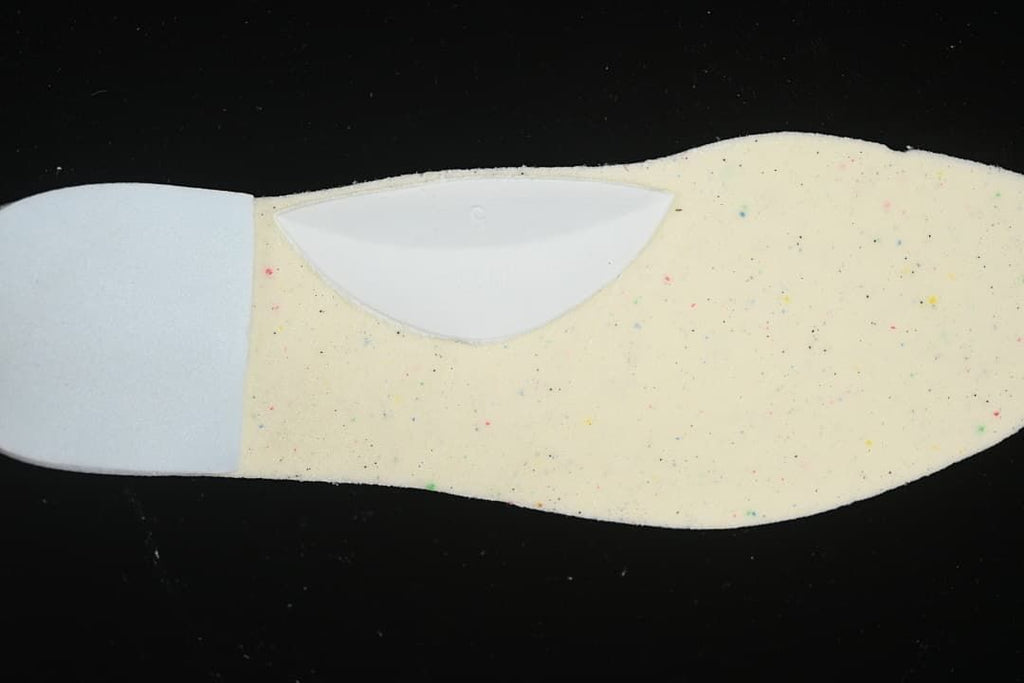Close-up of a light-colored shoe insole component