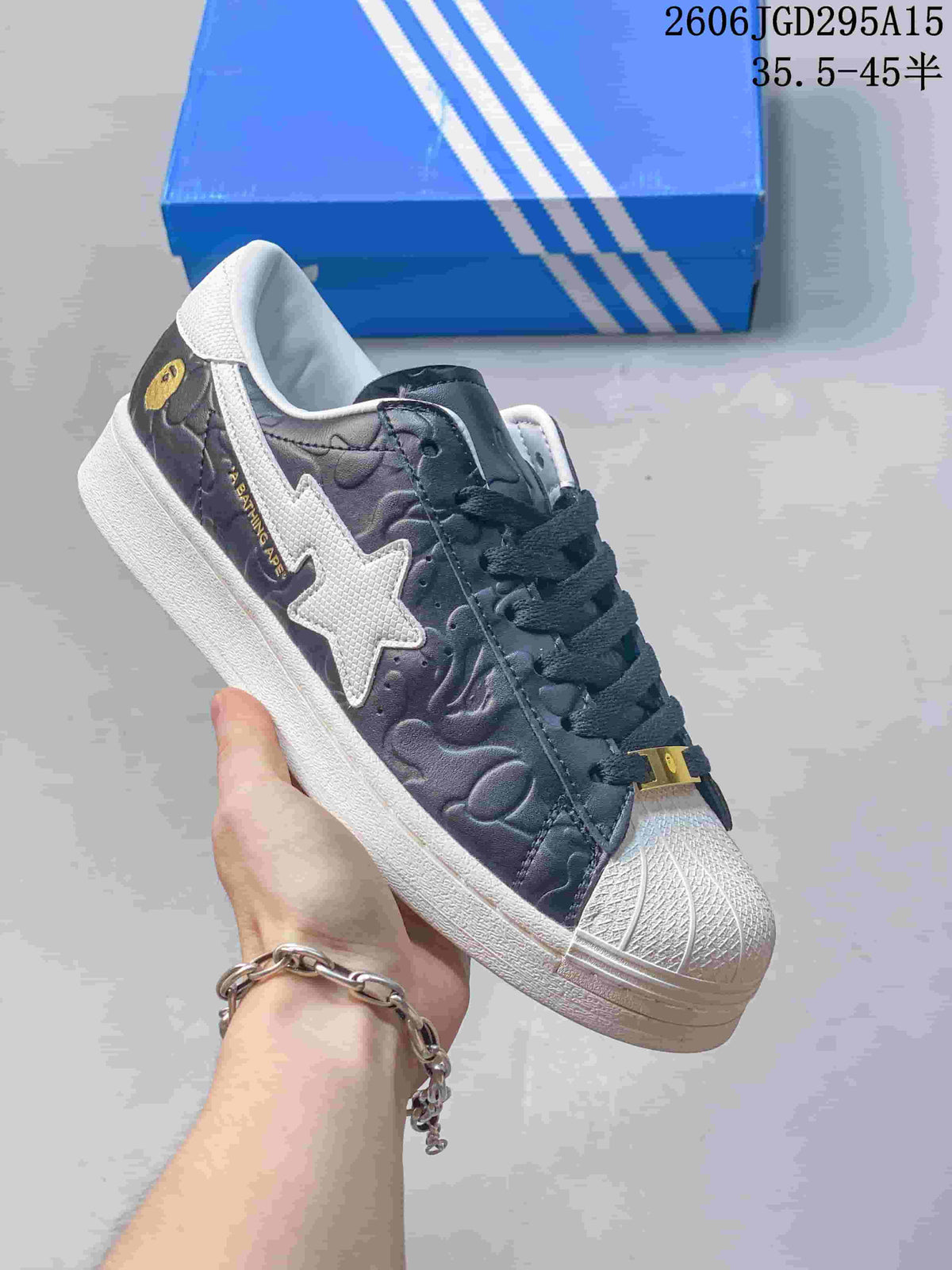 Dark sneaker with a white star-shaped side detail and shell toe