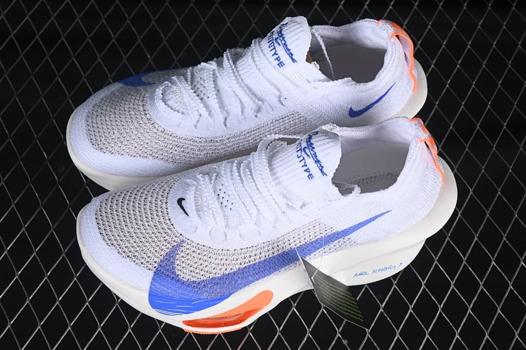 Pair of white running shoes with blue and orange accents