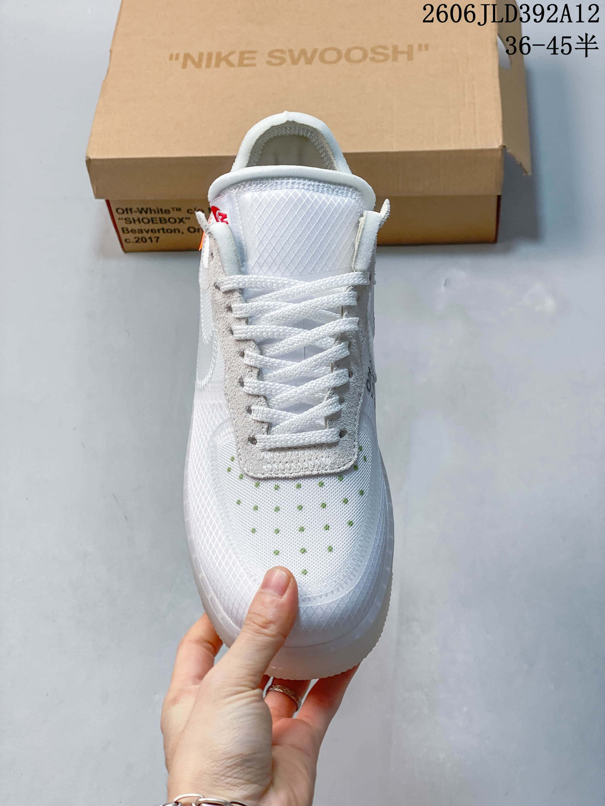 Front view of the white lace-up sneaker with small green toe accents