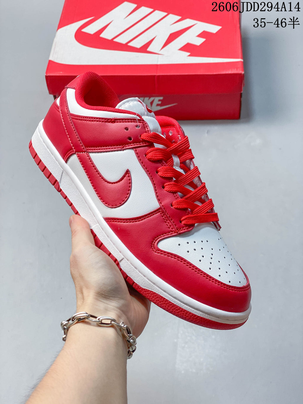 Angled side view of a red and white Nike Dunk Low sneaker.