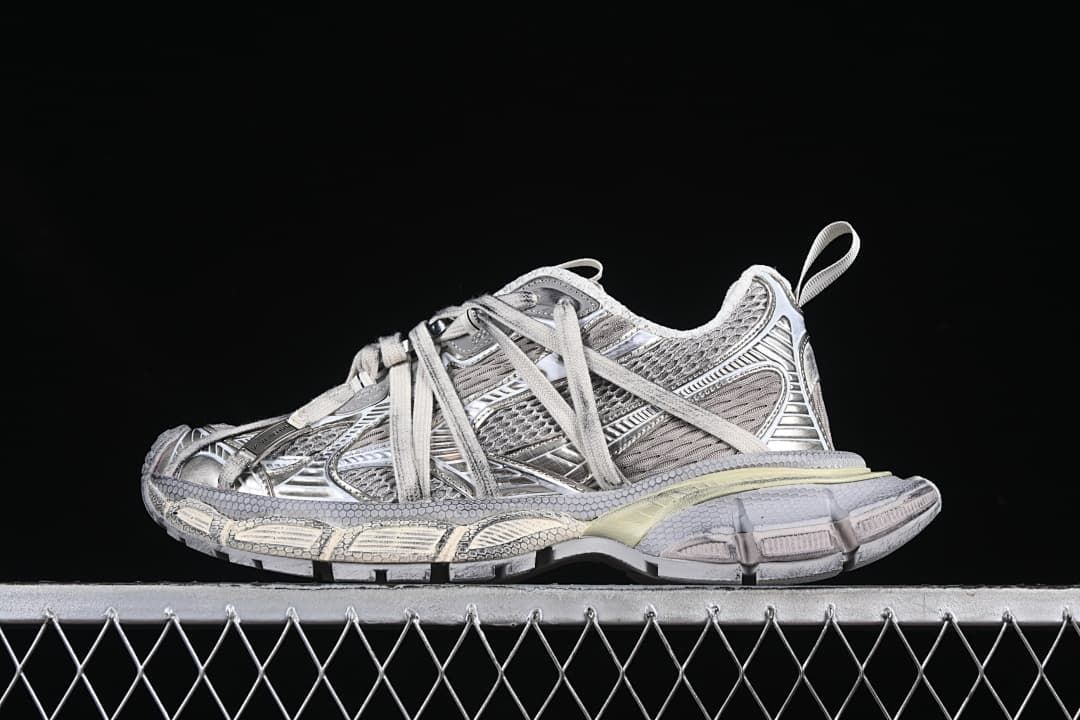 Side view of a silver and grey Balenciaga 3XL sneaker against a dark background