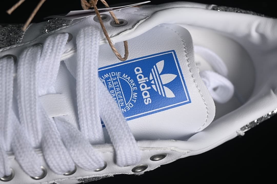 Close-up of the blue adidas tongue label and white laces.