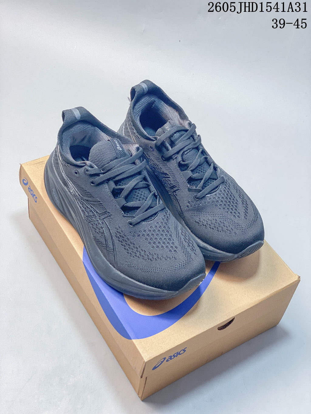 Dark gray ASICS GEL-NIMBUS 26 running shoes on a shoe box