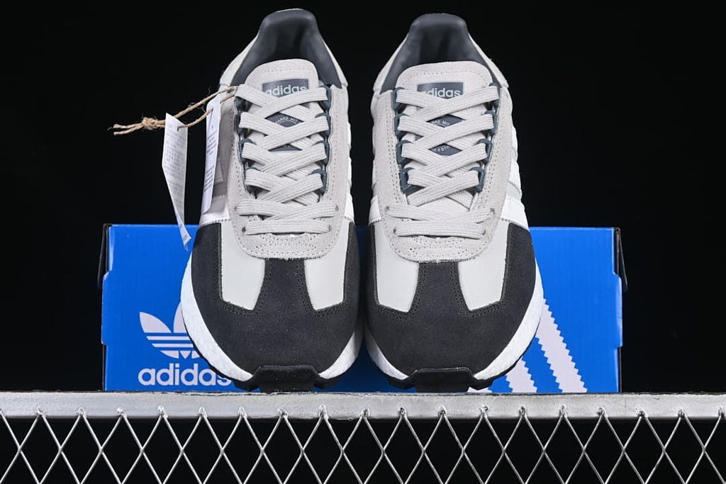Front view of both sneakers displayed on a blue adidas box