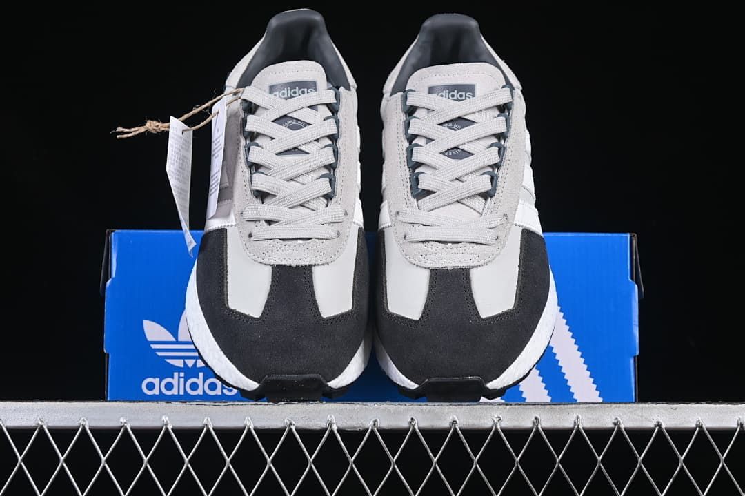 Front view of both sneakers displayed on a blue adidas box