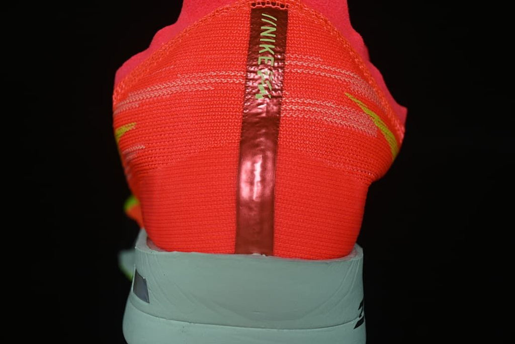 Rear view showing the coral-red heel and pale mint sole.