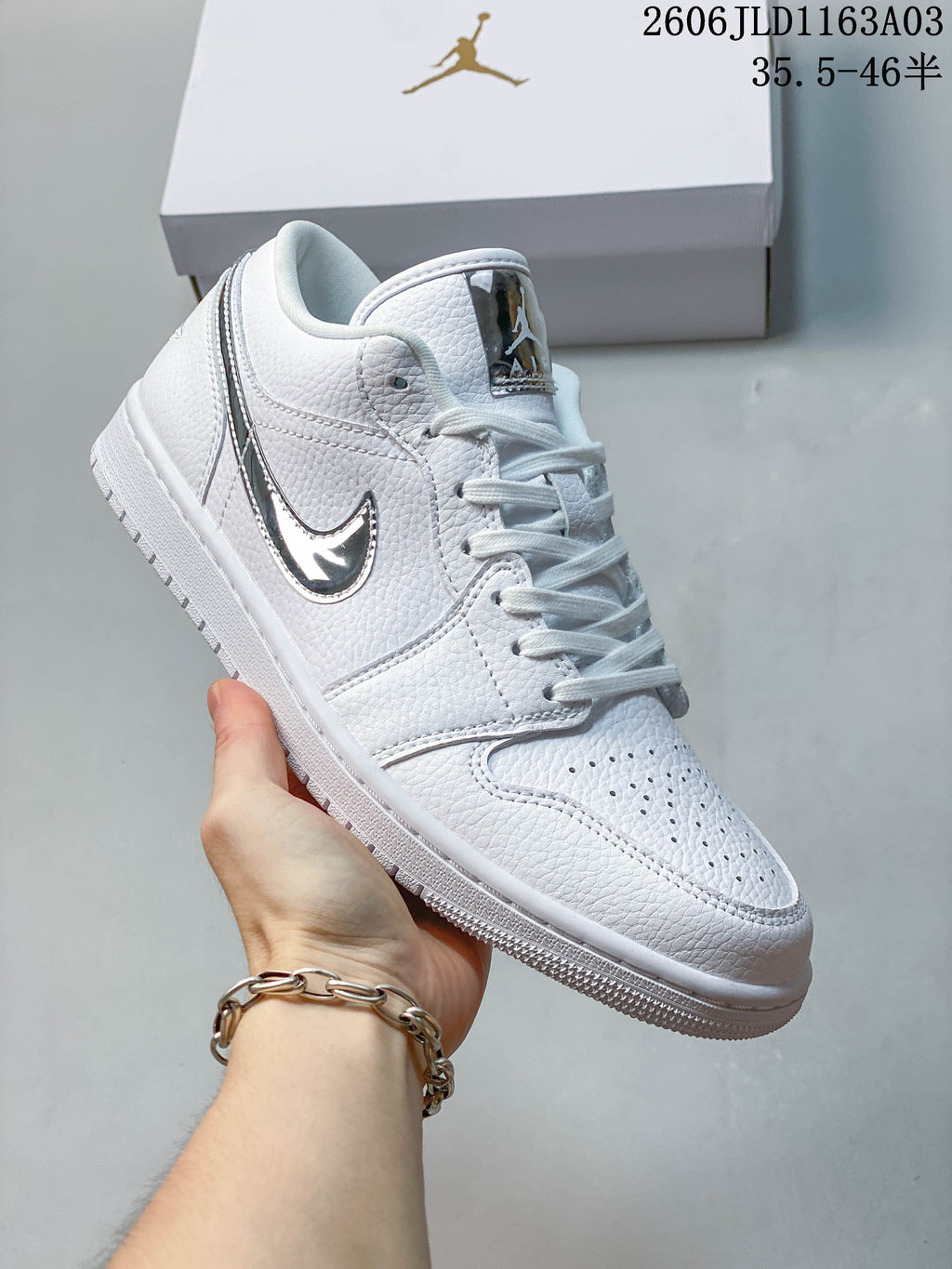 Angled side view of a white Jordan Air Jordan 1 SE low-top sneaker with reflective silver-tone accents.