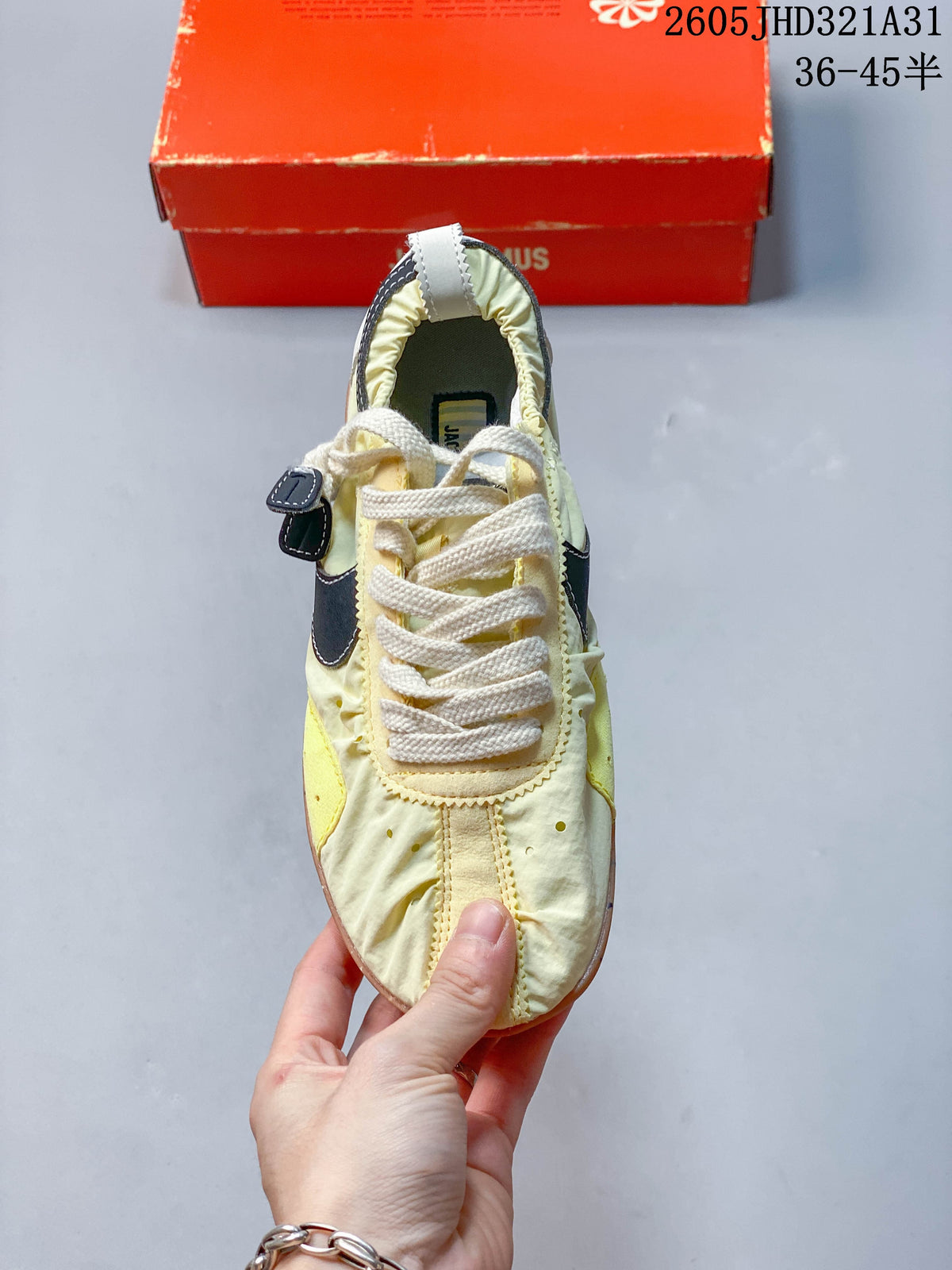 Top view of a pale yellow Nike x Jacquemus sneaker with cream laces