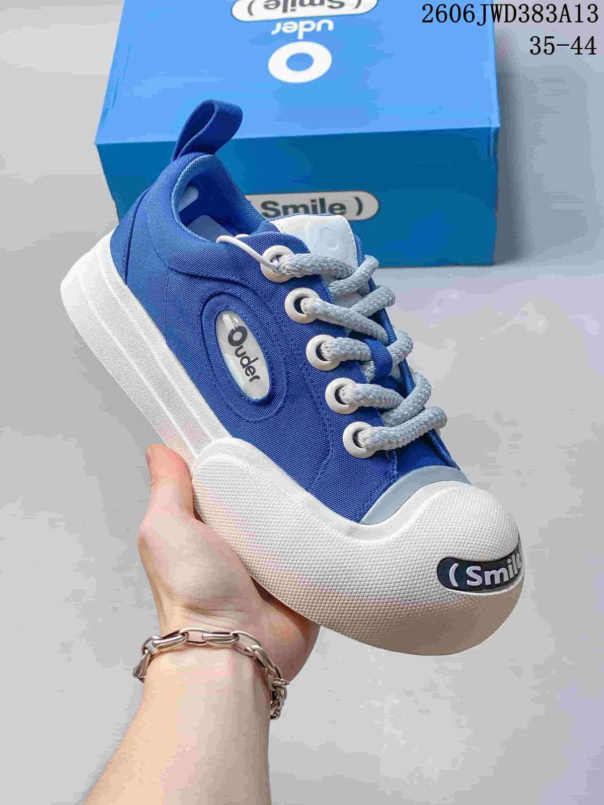 Angled view of the blue sneaker showing side branding, white laces and oversized toe bumper.
