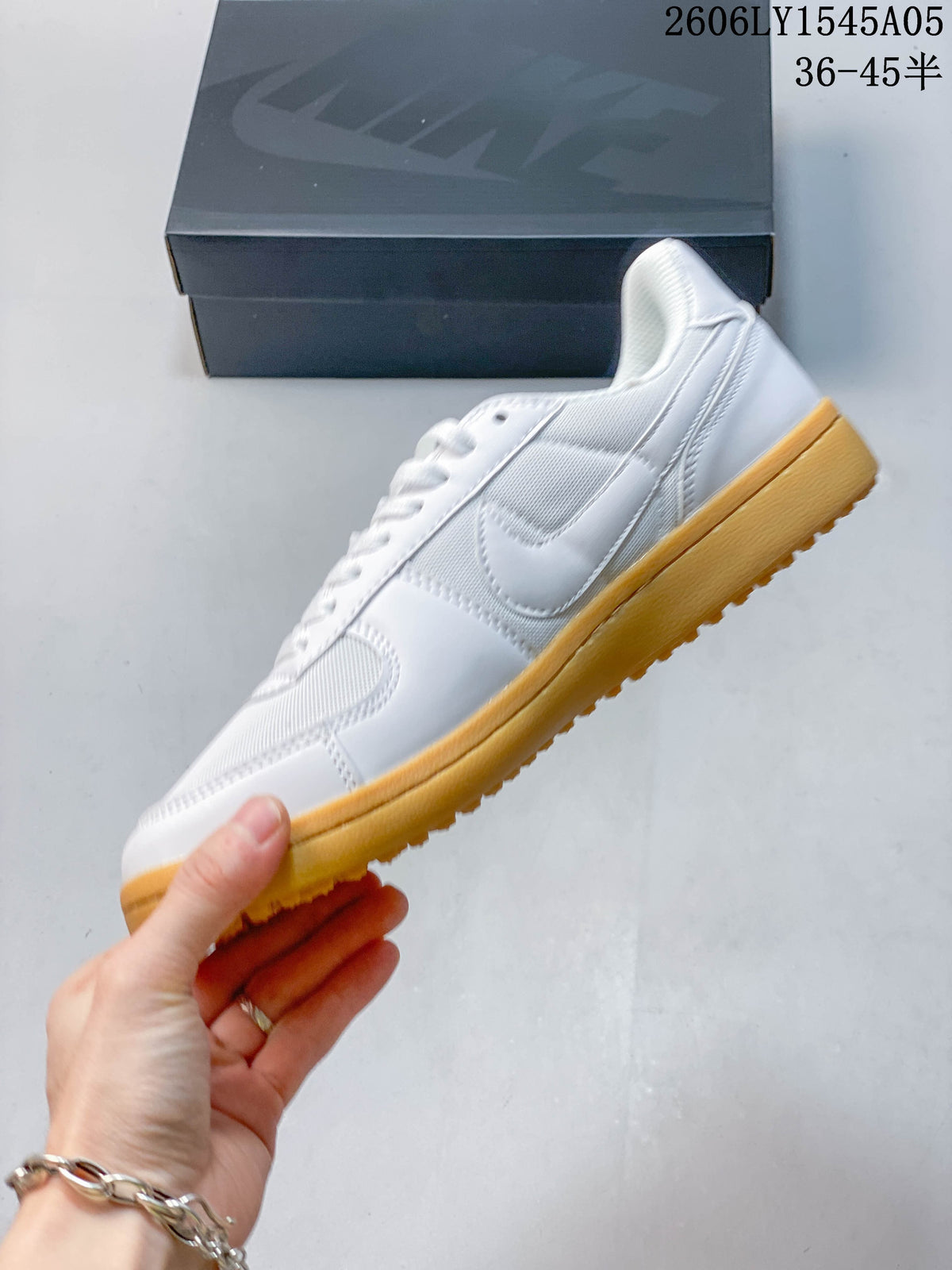 Side profile of a white Nike Field General sneaker with a Swoosh and gum-colored sole.